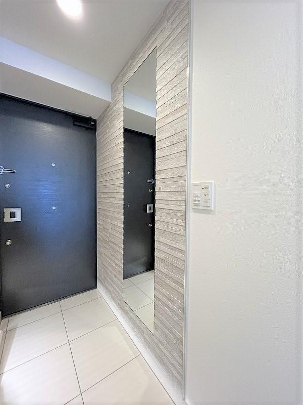 カサーレ小平の玄関|玄関部分には、新たにエコカラットと姿見を設置しました。エコカラットは、調湿や脱臭効果があります。また、姿見を設置することで、お出掛け前の身だしなみチェックもできます。