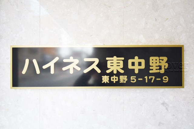 【現況写真】 | ハイネス東中野 | マンションの入り口に掲げられた、建物名称の表示部分。不動産業界ではこれを「館銘板」と呼びます。～即日のご見学可能～　お問合せはお気軽にどうぞ。
