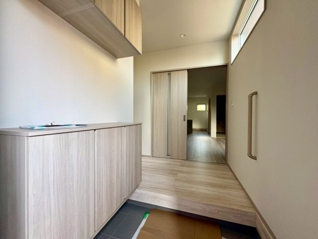 「続き間で23帖超えの大空間」香美市土佐山田町東本町2号棟　新築一戸建ての玄関|木の温もりを感じる玄関ホール。手すり付きで昇り降りも安心です。シューズボックスの上は、お気に入りの雑貨を飾るディスプレイスペースとしても楽しめます。