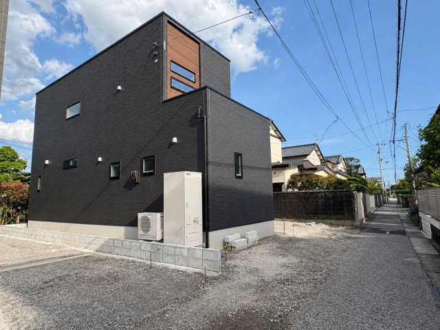 「続き間で23帖超えの大空間」香美市土佐山田町東本町2号棟　新築一戸建ての前面道路含む現地写真|シックな黒の外壁に木目調のアクセントが際立つ、スタイリッシュな外観。周辺は落ち着いた住宅街で、日当たりも良く開放感のある立地です。