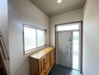 【玄関】 | 千葉市緑区誉田町　中古4LDK　JR外房線「誉田」駅 | 光がたっぷり入る明るい玄関は、家族を温かく迎えてくれる心地よい空間。清潔感のある白壁に木目調の靴箱が優しく馴染み、毎日の外出や帰宅を楽しくしてくれます。自然光に包まれる、開放感あふれる玄関が魅力です。