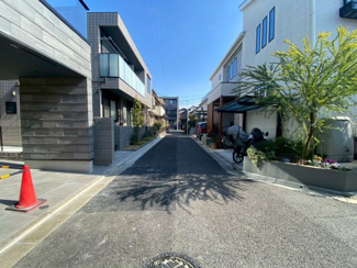 【前面道路含む現地写真】 | 青空が広がる静かな住宅街。隣地との距離も適切に保たれ、プライバシーと日当たりを両立した設計です。交通量も少なく、落ち着いた環境で新しい生活を始めたいご家族にぴったりのロケーション。