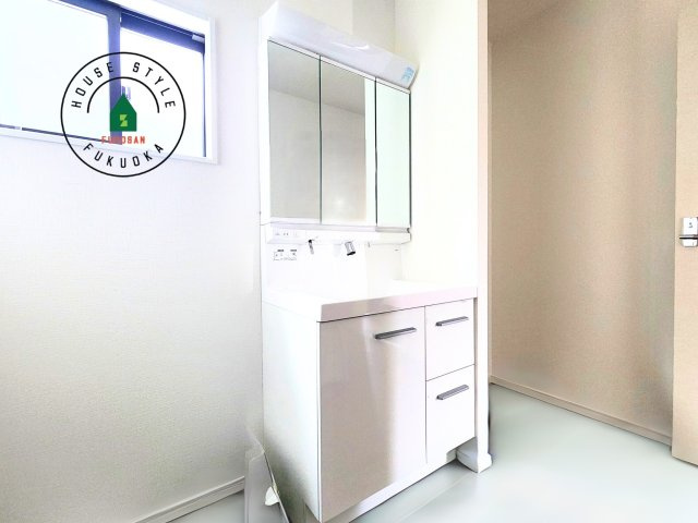 筑紫野市大字阿志岐第3-3棟（2号棟）の内観：施工例|毎日使うものだから清潔な空間を保ちたい水回り。洗面にはそんな願いを解消させてくれる収納アイデアが満載です。三面鏡の裏側にはキャビネットが現れ小物から背の高い物まで収納できます。