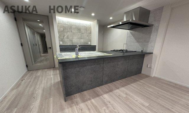 コスモ新横浜の居間・リビング|ダークな色合いのおしゃれなキッチンのカウンターはイスを置いてお洒落なカフェタイムが楽しめそうですね。