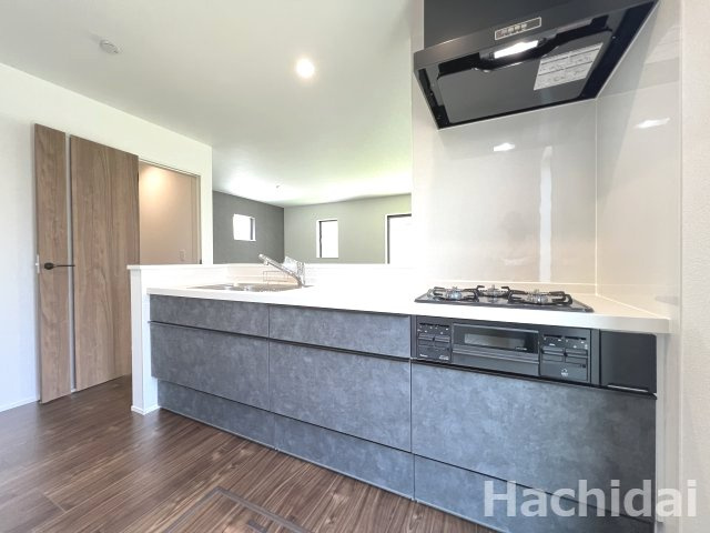 碧南市坂口町2丁目1期　新築戸建＜2号棟＞のキッチン|濃いグレーでまとめた、高級感のある落ち着いた色味のシステムキッチンです♪リビングと調和するモダンなデザインです。