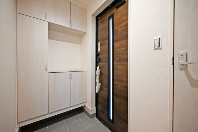 リーブルガーデン武庫之荘5丁目新築一戸建て│3LDK+駐車1台可の玄関|1階玄関を廊下側から撮影した内観写真です。
シンプルな玄関扉にシューズボックスを配置したオーソドックスな玄関です。