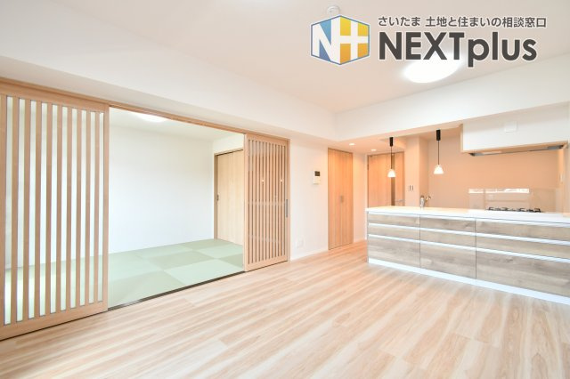 ファミール大宮宮原壱番館の居間・リビング|キッチンから和室まで視線が抜け、実面積以上の広さを感じる大空間。格子戸の和室を繋げれば、家族構成やシーンに合わせた柔軟な使い方が可能です。ナチュラルな木目と白壁が、明るく穏やかな日常を演出します。