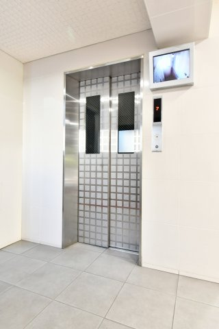 ファミール大宮宮原壱番館のその他共用部分|【エレベーター】共用エレベーターと防犯モニターの様子。日々使う設備なので、広さや待ち時間、作動状況は内覧時に確認がおすすめ。停止階・点検履歴、混雑時間帯や防犯体制は管理規約等で要確認。