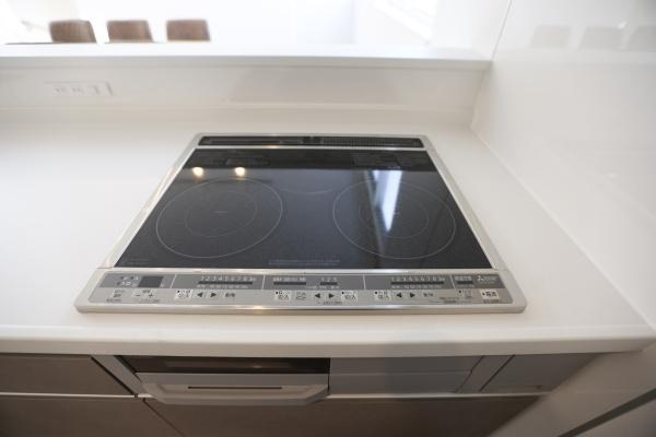上野丘E　新築のキッチン|ガラストップのIHクッキングヒーターが設置されています。お手入れしやすいフラットなデザインです。キッチンまわりがすっきりとした印象になります。