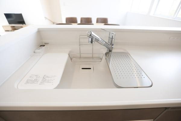 上野丘E　新築のキッチン|シンプルで洗練された白いシンクに、蛇口一体型の浄水器が加わり、機能性と美しさを兼ね備えています。広めのシンクで、料理や洗い物もスムーズにこなせます。