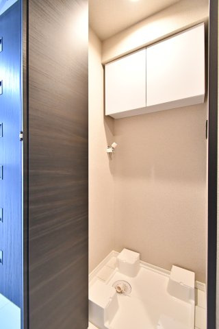 ライオンズプラザ大宮のランドリースペース|室内洗濯機置き場は防水パン付きで設置がしやすい形状。上部収納も備わり、洗剤やタオル類をまとめて保管できます。可動棚なので高さ調整もしやすく、洗濯ネット等の小物整理にも便利です。家事がはかどります。