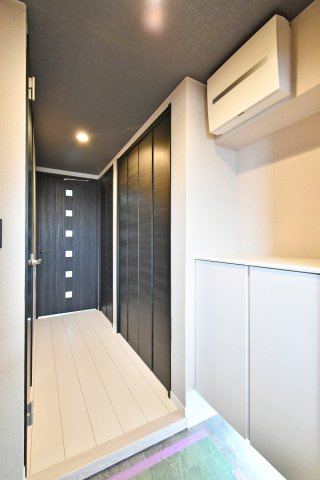 ライオンズプラザ大宮の玄関|廊下まで見渡せる玄関アプローチ。黒い建具が空間を引き締め、照明付きで手元も明るい印象です。シューズボックスも備わり、来客時も玄関が整えやすい設計。出入り口の視界も確保でき、安心感も。