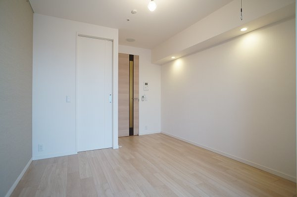 プライムメゾン森下の居間・リビング|バルコニー側から洋室（ダウンライトがポイント）