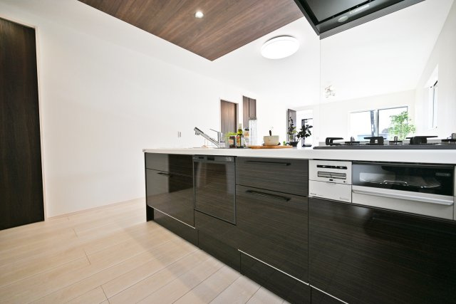 伊丹市寺本1丁目新築一戸建て│3SLDK+並列駐車2台可のキッチン|キッチンの上部には空間のアクセントとなる折り下げ天井あり。ダウンライトも配置してあり、落ち着いた雰囲気のキッチンです。
