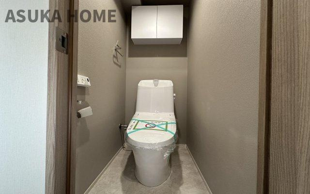 菱興洋光台マンションのトイレ|温水洗浄便座のトイレ設備です。トイレ上部にはあると便利な吊戸棚やタオル掛けを設置。