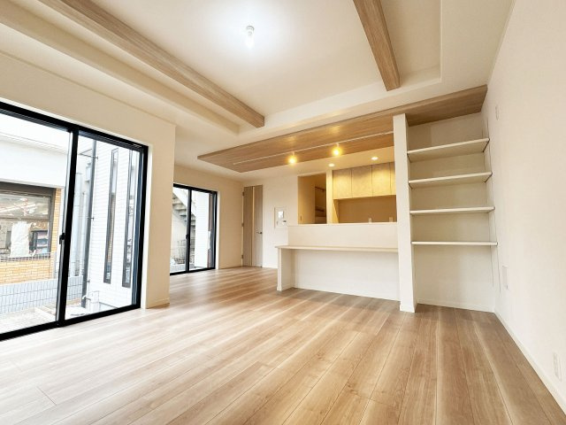 【居間・リビング】 | トラストステージ×カラーズ　富士見市針ヶ谷2丁目8期　全3棟 | 【3号棟/LDK】
キッチン裏にスタディカウンターがあり、お料理中もお子様の学習を見守れます。
リビングの可動棚には雑貨を飾るのもオシャレです！