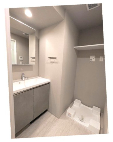 ニド元浅草の洗面所|トイレと独立した脱衣洗面室、洗面台の下にヘルスメーターストックスペースあります、洗濯機置場の排水口のお手入れしやすい様に手前中央に配置し、足高の防水パンです