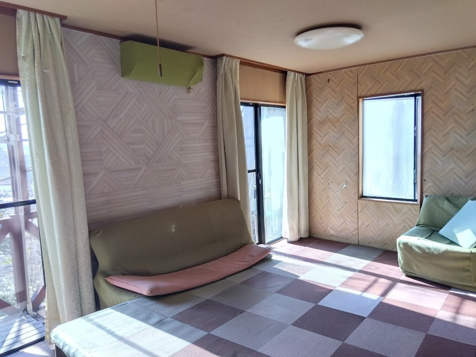 売中古戸建　三島市若松町の居間・リビング|二面採光で明るく開放的な居室空間です。大きな窓からたっぷりと自然光が差し込み、日中は照明いらずの心地よさです。木目調のクロスが温かみを演出し、落ち着いた雰囲気の中でゆったりと過ごせます。