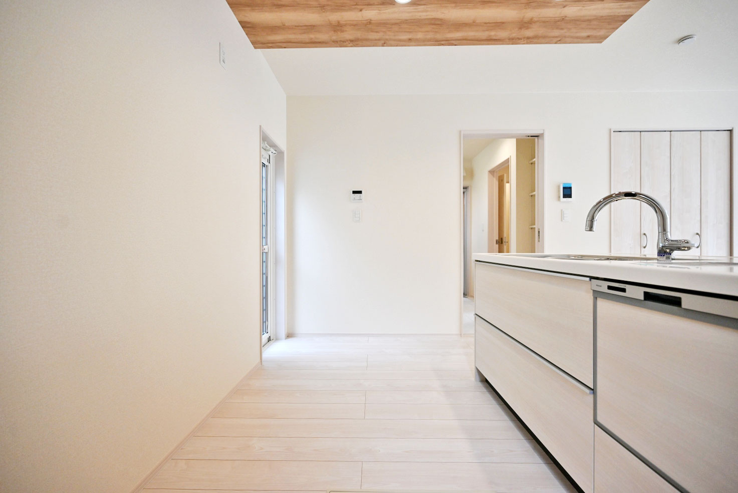 ブルーミングガーデン小林5丁目新築一戸建て│3LDK+並列駐車3台可のキッチン|1階キッチンユニット越しに撮影した内観写真です。対面式キッチンを採用しているため視界は広く、ご家族間やご来訪者とのコミュニケーションも一体的に取り易くなっております。