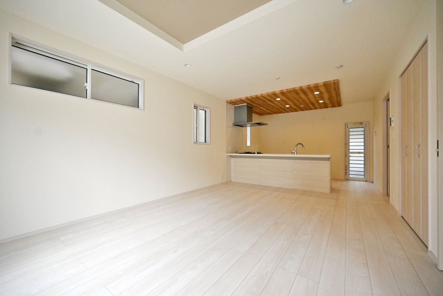 ブルーミングガーデン小林5丁目新築一戸建て│3LDK+並列駐車3台可の居間・リビング|対面式キッチンで家族同士のつながりを感じやすい設計を基調としています。折上天井やアダウンライトを設けるなど、デザイン性を向上させた内観に仕上がりました。