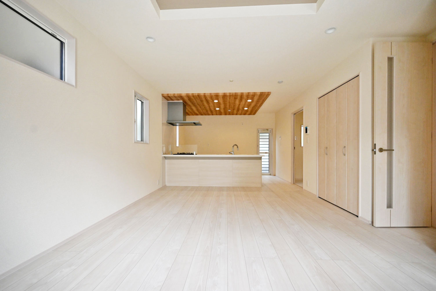 ブルーミングガーデン小林5丁目新築一戸建て│3LDK+並列駐車3台可の居間・リビング|1階LDKをダイニング側から正面に撮影した内観写真です 。 未就学児も含む4人家族がゆとりをもって過ごすには十分の1棟です。