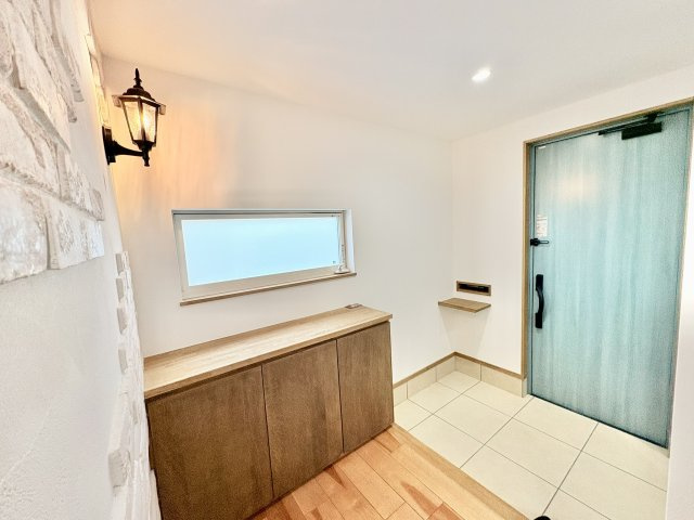 売中古戸建　中央区富塚町の玄関|ヴィンテージ風のライトとブロックモチーフの壁面が素敵な玄関です。