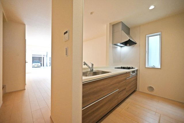 リーブルガーデン尼崎市常松1丁目新築一戸建て全4区画│2SLDK＋駐車2台可の玄関|1階キッチンユニット越しに撮影した内観写真です。対面式キッチンを採用しているため視界は広く、ご家族間やご来訪者とのコミュニケーションも一体的に取り易くなっております。