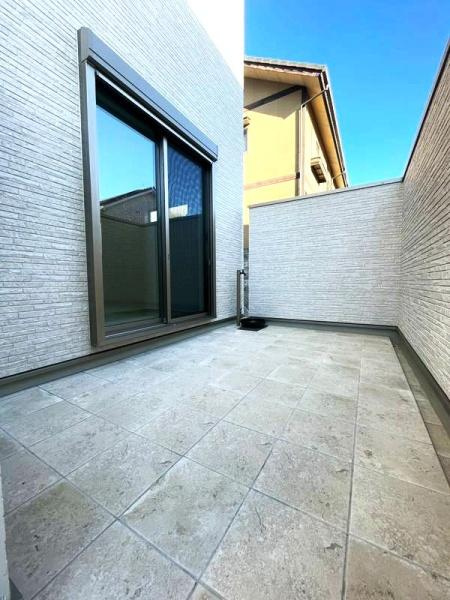 HT挾間のバルコニー|広々としたタイル貼りのバルコニーが魅力です。高い壁でプライバシーも確保されています。清潔感のある空間で快適に過ごせます。