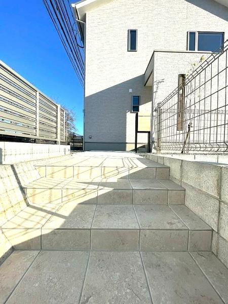 HT挾間のその他|明るい空間にマッチしたタイル階段が印象的です。シンプルな外観と調和するデザインです。住宅のアクセントとなるアプローチが魅力です。手すりやフェンスで安全性にも配慮されています。