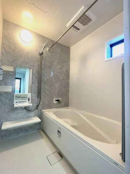 HT挾間の浴室|明るい照明と窓からの採光で室内が開放的な印象です。浴槽は足を伸ばせる広さがありゆったりとした造りです。壁面は清潔感があり手入れもしやすい素材が採用されています。