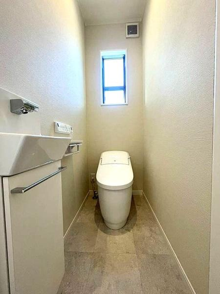 HT挾間のトイレ|清潔感のある明るいトイレです。スリムな手洗いと収納が設けられています。窓が付いているため自然光が入りやすい設計です。シンプルな内装でお手入れもしやすそうです。