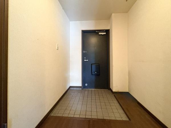 ドゥペールワコー城東のエントランス|タイル張りの壁が印象的なエントランスです。掲示板には案内やお知らせが整理して掲示されています。落ち着いた照明が空間を明るくしています。