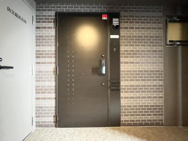 クレアネクスト古国府ザ・タワーの玄関|セキュリティと機能性両方を兼ね備えた玄関。落ち着いたトーンの玄関ドアが印象的です。レンガ調の壁面がアクセントを加えています。シンプルで機能的なデザインが特徴です。モダンな雰囲気を感じられます。
