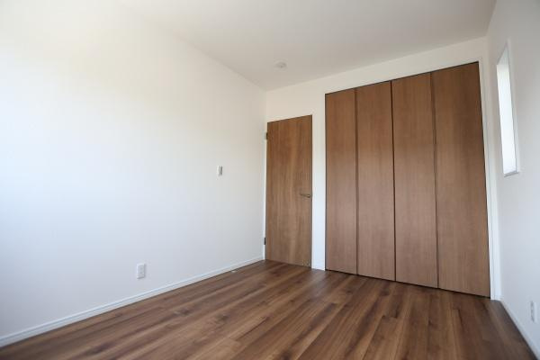 P-TELAS牧１丁目3号地の洋室|ナチュラルな木目調のフローリングが特徴の洋室です。明るい白壁で室内が広く感じられます。収納スペースも確保されておりすっきりとした印象です。