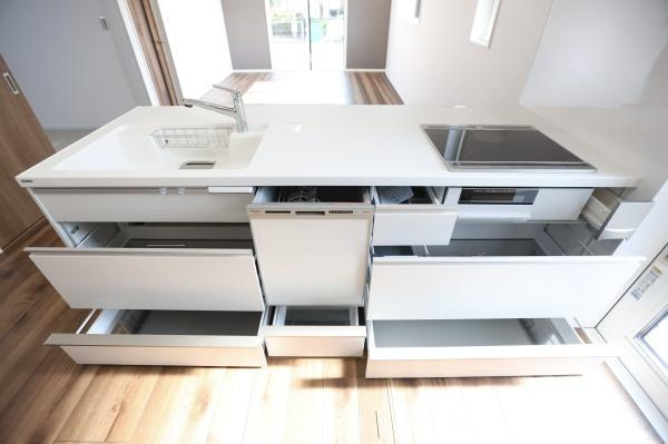 P-TELAS牧１丁目3号地のキッチン|キッチンは引き出し収納が豊富で整理整頓しやすい仕様です。シンクとIHコンロが合理的に配置されています。食器洗い乾燥機も設置されており利便性が高いです。明るい床と白い天板が清潔感を演出しています。