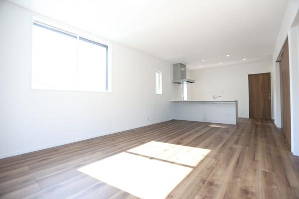 P-TELAS牧１丁目3号地の居間・リビング|大きな窓から光が差し込むリビングは室内が明るい印象です。床材の風合いが空間に温もりを与えています。ダイニングスペースも使いやすい配置です。シンプルな内装が好みに合わせてコーディネートしやすいです。