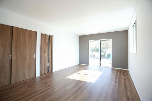 P-TELAS牧１丁目3号地の居間・リビング|明るい日差しが差し込むリビングはすっきりとした内装と木目調の床が特徴です。開放感のある広々とした空間が広がっています。大きな窓から外の景色も楽しめます。