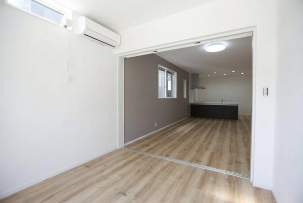 P-TELAS牧１丁目2号地の洋室|引き戸で仕切られた洋室は隣接する空間との一体感を感じられます。シンプルで整った内装が印象的です。明るい床材と白い壁が清潔感を演出しています。天井近くの窓から自然光が入り室内をより明るくします。