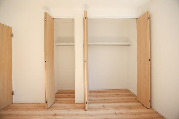 P-TELAS牧１丁目2号地の収納|木目調の扉が温かみを感じさせる収納スペースです。大きく開閉できる扉で使い勝手が良好です。内部はハンガーパイプと棚が備わっており整理しやすい仕様です。余裕のある広さで衣類や荷物もすっきり収められます。