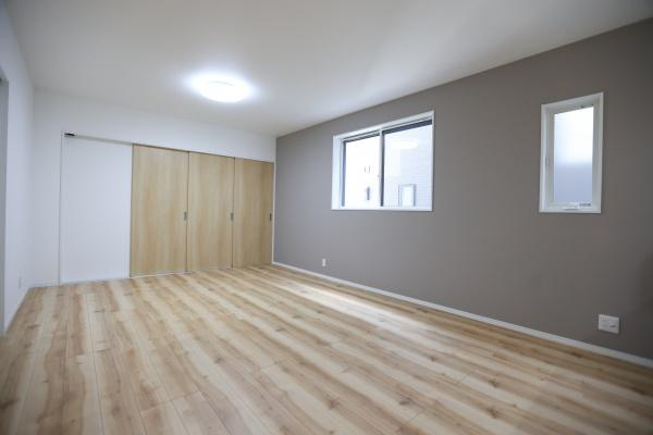 P-TELAS牧１丁目2号地の居間・リビング|リビングは明るい色合いのフローリングが印象的です。大きな窓から自然光が入りやすくなっています。壁の一部はアクセントカラーで落ち着いた雰囲気を感じられます。収納スペースも充実しています。