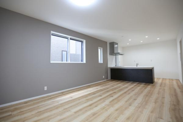 P-TELAS牧１丁目2号地の居間・リビング|広々とした空間が印象的なリビングです。大きな窓から明るい光が差し込み開放感があります。ナチュラルなフローリングがやわらかな雰囲気を演出しています。キッチンも隣接しており使い勝手も配慮されています。