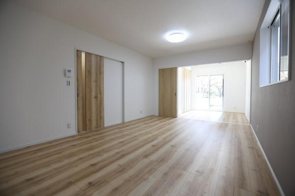 P-TELAS牧１丁目2号地の居間・リビング|リビングは明るい光が差し込む空間です。床材のナチュラルな色味が室内をより広々とした印象にしています。窓からは外の様子が見やすく開放感があります。