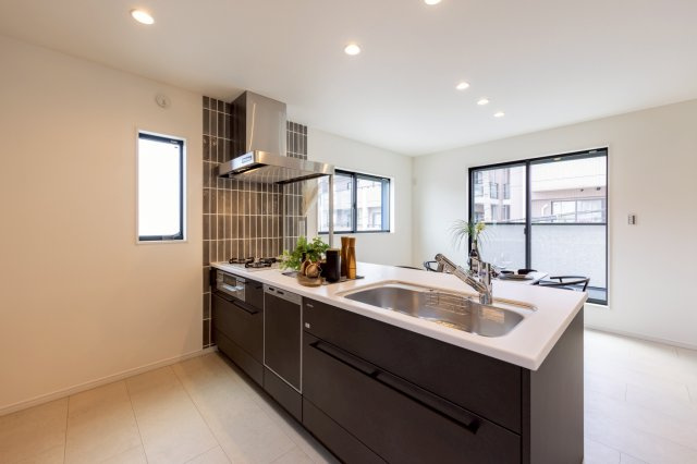 神戸市灘区高尾通1丁目新築一戸建て│3LDK+駐車2台可(車種制限有)のキッチン|2階LDKをキッチンユニット越しに撮影した内観写真です。フルフラットの対面式オープンキッチンを採用しているため視界は広く、ご家族間やご来訪者とのコミュニケーションも一体的に取り易くなっております。