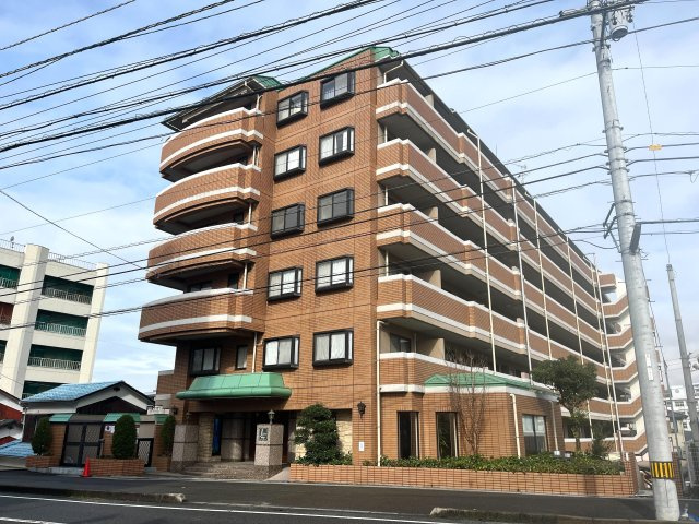 ジェイシティ道後石手の外観|落ち着いたタイル貼りのRC造7階建マンション。5階部分の角部屋という恵まれたポジションで、外から見ても堂々とした佇まいです。植栽やエントランスも手入れが行き届き、帰宅のたびに安心します。