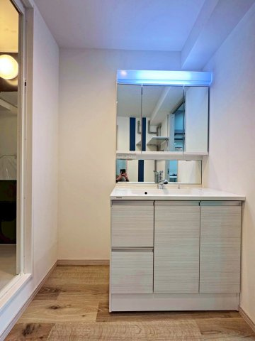 今福西コーポの独立洗面台|ワイドな三面鏡を備えた洗面化粧台。
洗面下にはたっぷり収納スペースがございます。