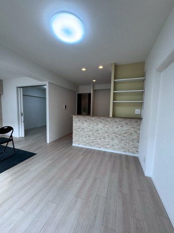 日商岩井菫橋ハイツの居間・リビング|カウンターキッチン横に棚付きで収納力もあります。