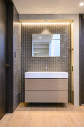 【洗面所】 | タイル貼りの壁面が印象的な、ホテルライクな洗面空間です。足元が浮いたフロートタイプは掃除がしやすく、清潔感を維持できます。鏡の上下に配した間接照明が、朝の身支度を心弾むひとときへと変えてくれます♪