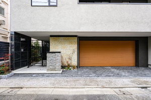 【外観】 | 明るい時間帯には、質感豊かな外壁と植栽のコントラストが映えます。シンプルながらも洗練されたデザインは、街並みに調和しつつ個性を主張。エントランス横の石積みが、玄関先に重厚なアクセントを添えています。