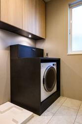 【ランドリースペース】 | 洗濯機をスマートに収める専用スペースを設置。上部には可動棚を備え、洗剤やリネン類も効率よく収納できます。家事動線を考慮した機能的な配置で、毎日の洗濯がより軽やかに、心地よい時間へと変わります！