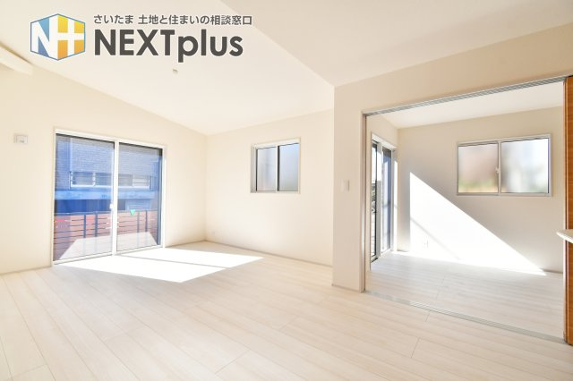 上尾市原市全1棟　1号棟の居間・リビング|大きな窓から陽光が降り注ぐ、明るく開放的な17帖のリビング。平屋ならではの勾配天井が、実際の面積以上のゆとりと心地よい開放感を演出します。家族が自然と集まる、温もりに満ちた中心空間です。